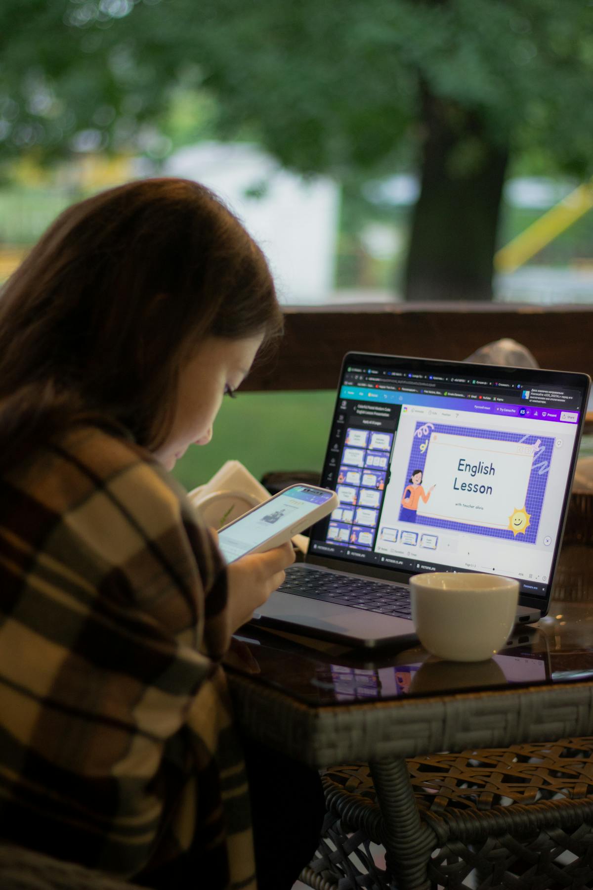 Woman using laptop and smartphone — multi-device connected learning